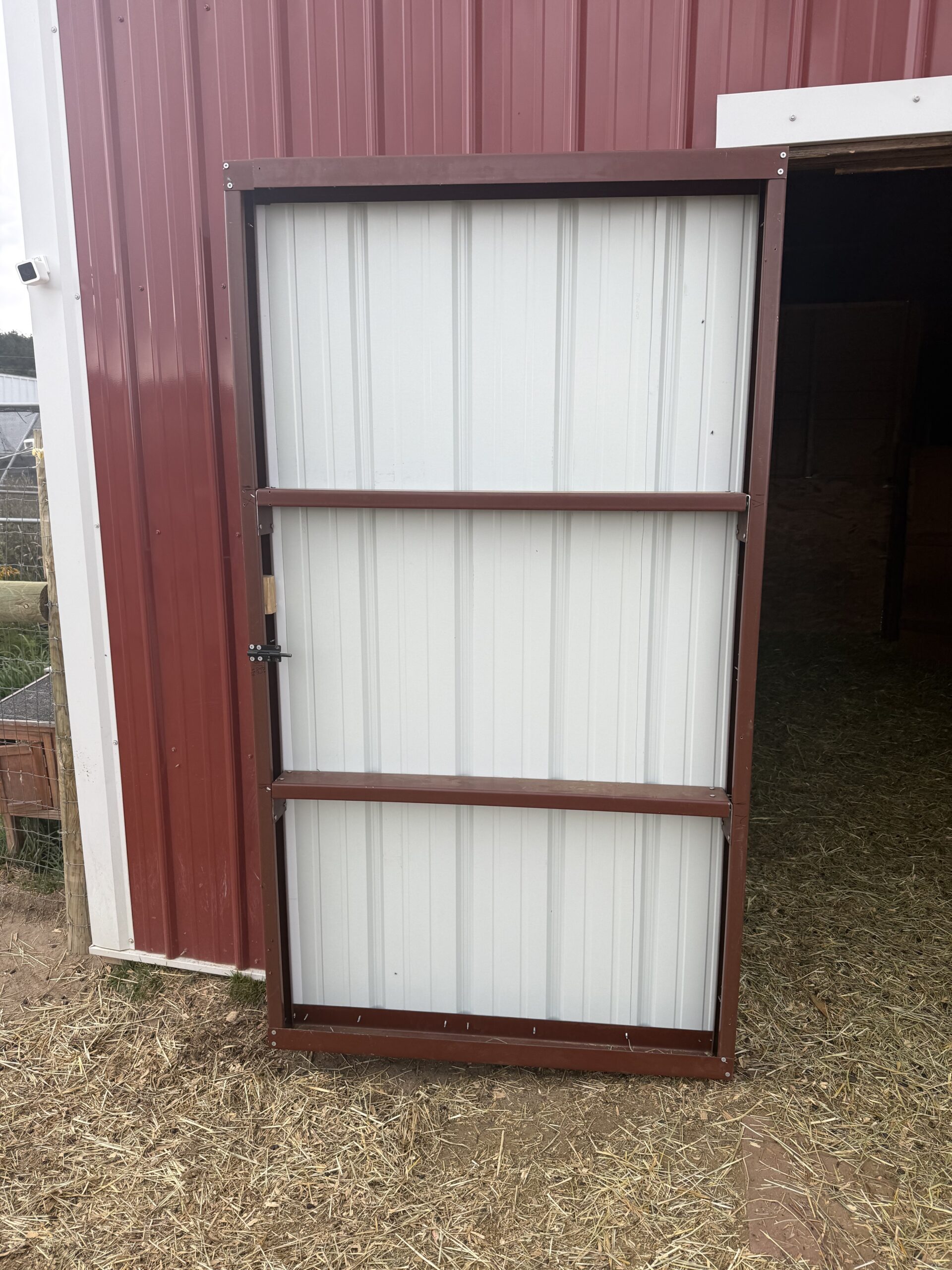 Custom steel barn doors on red and white barn